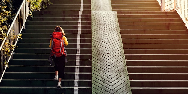 Free photo girl with a backpack walking up the stairs