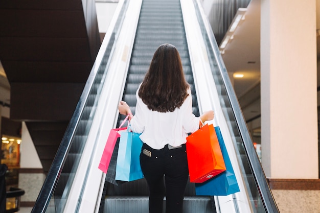 Girl with bags on escalator