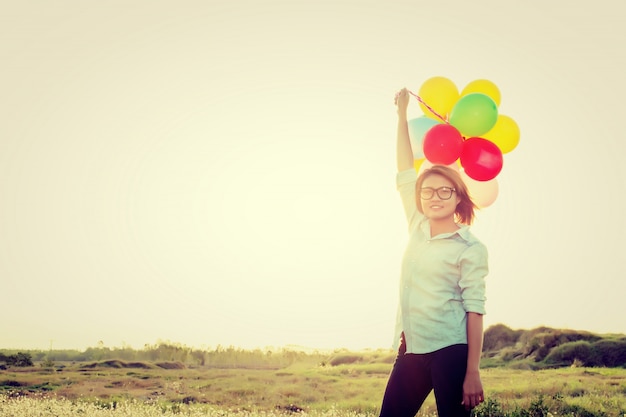 Girl with balloons aloft