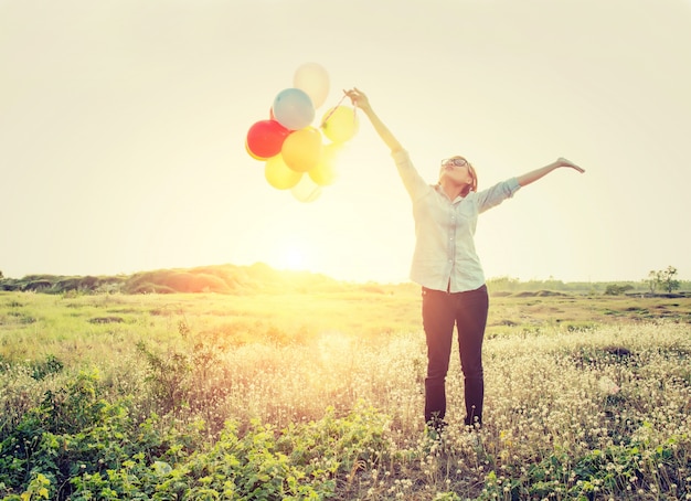 Girl with balloons and arms outstretched
