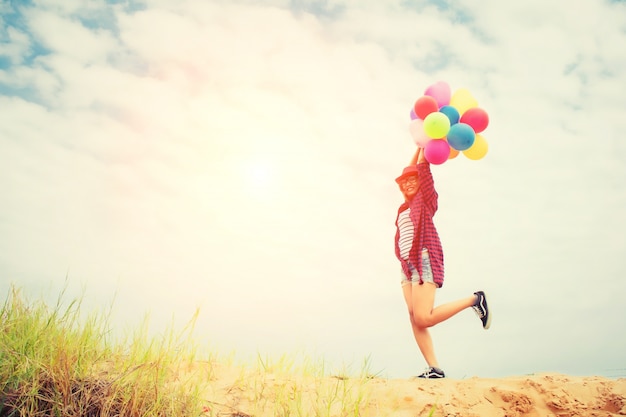 Девушка с воздушными шарами на пляже