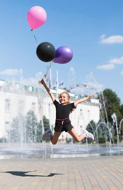 Girl with balloons at fountain