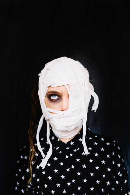 Girl with bandaged face rolling eye