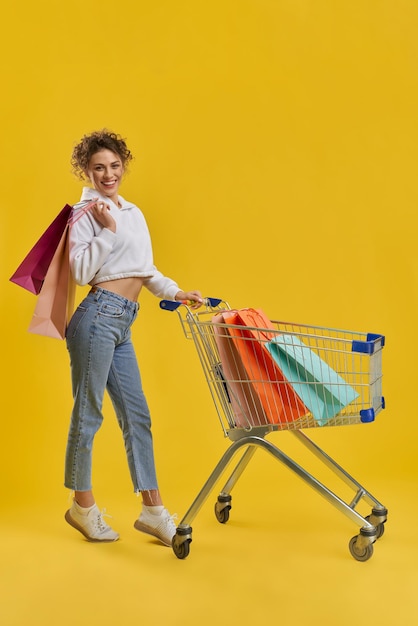 Free photo girl with blonde curly hair doing shopping