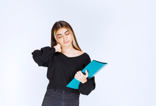 Girl with a blue folder feeling tired and sleepy. High quality photo