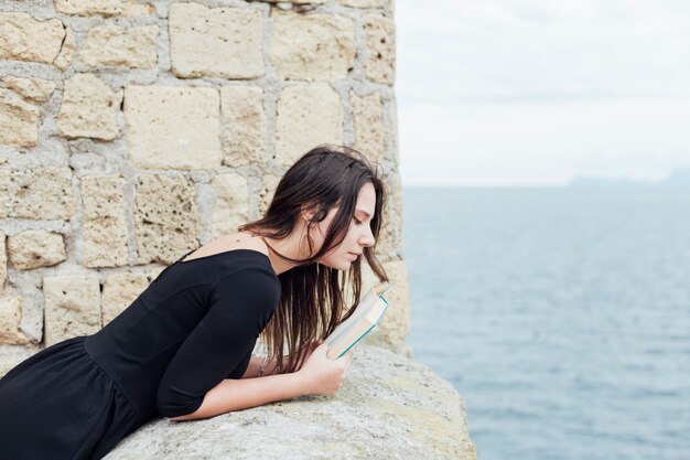 海の近くの本を持つ少女