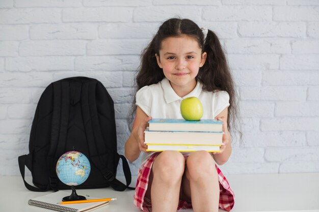 Ragazza con libri e mele