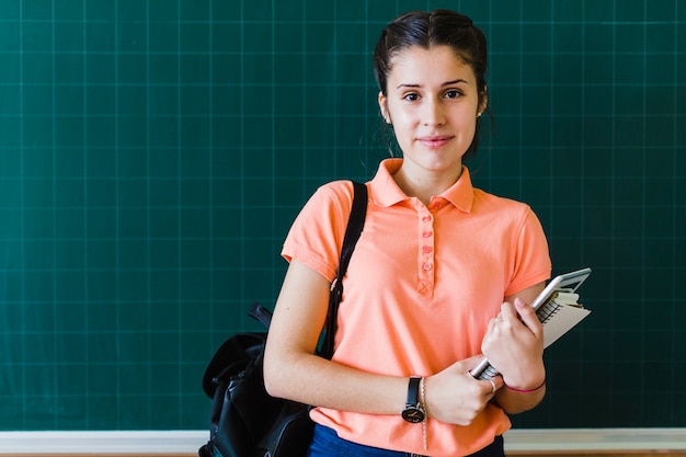 Girl with books and blackboard