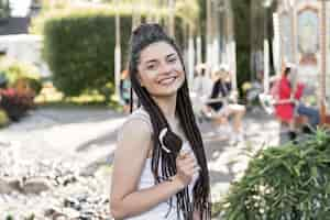 Free photo girl with box braid hairstyle holding an ice cream