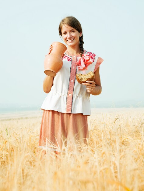 Girl in with bread and jug at  field