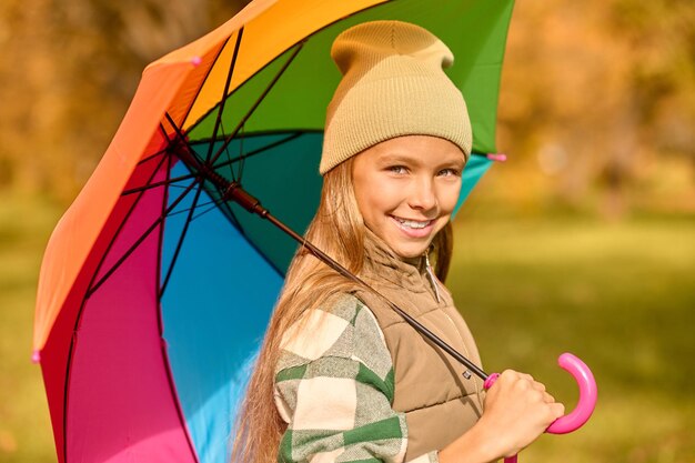 A girl with a bright umbrella in an autumn park