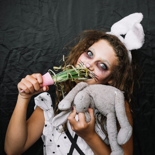 Free photo girl with bunny ears eating green onion