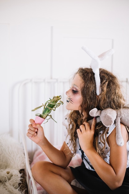 Girl with bunny ears smelling plant