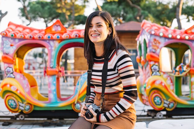 Girl with camera in front of a ride