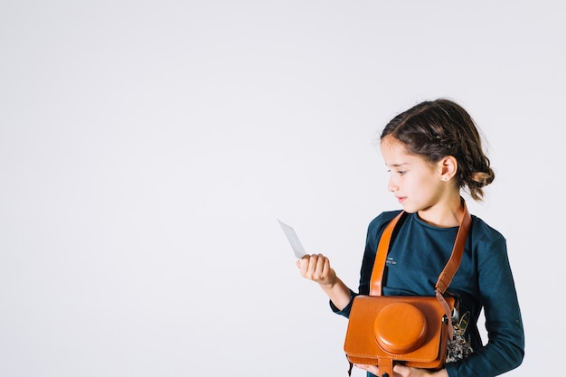 Girl with camera looking at photo