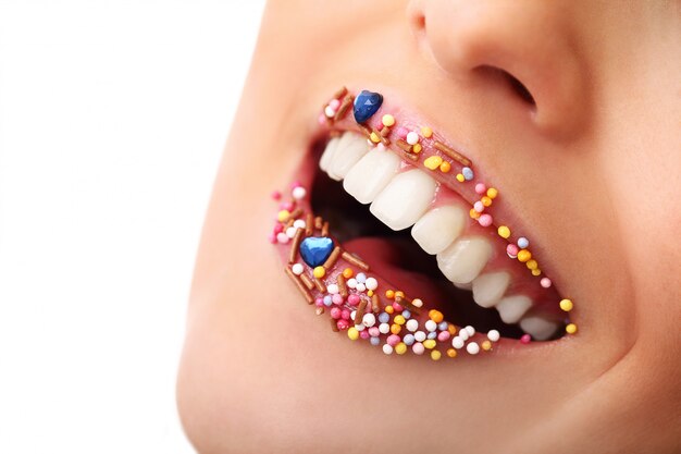 Girl with candy toppings on lips. Sweet sugar lips