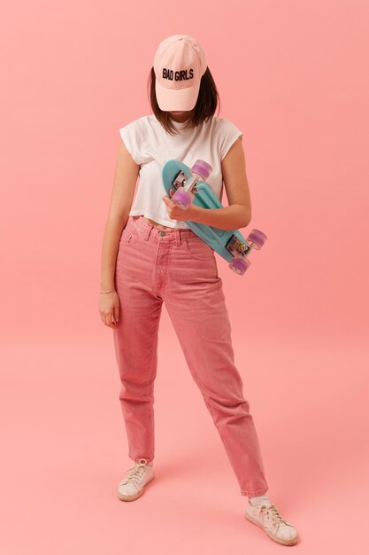 Girl with cap holding skateboard