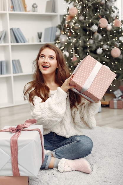 Free photo girl with christmas boxes. woman at home. ladu preparing for holidays.