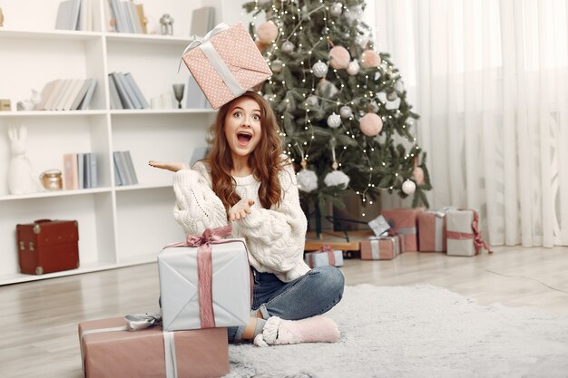 Girl with Christmas boxes. Woman at home. Ladu preparing for holidays.