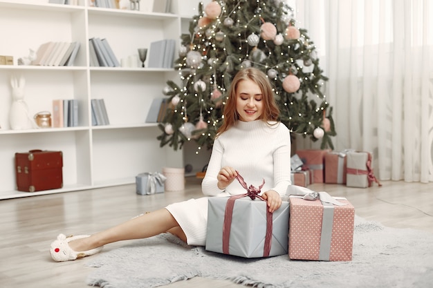 Girl with Christmas boxes. Woman at home. Ladu preparing for holidays.