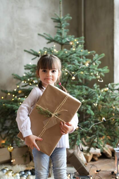 Girl with Christmas tree and present