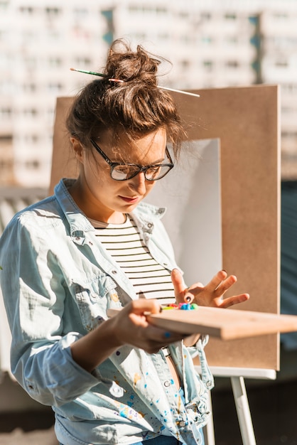 Foto gratuita ragazza con tavolozza di colori all'aperto