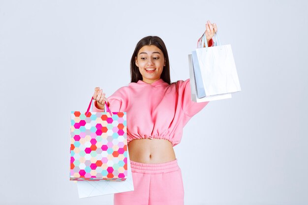 Girl with colorful shopping bags looks happy and satisfied. 