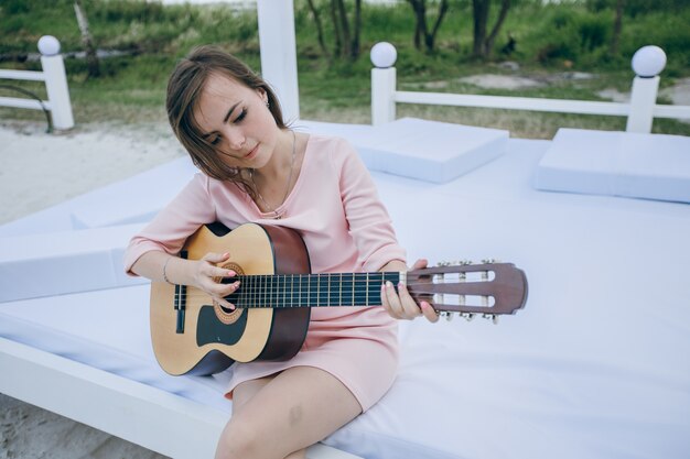 Girl with crooked head while playing a guitar