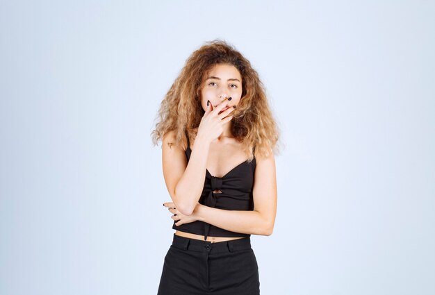 Girl with curly hairs looks thoughtful. 