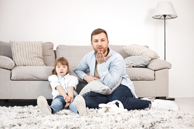 Girl with Down syndrome and her father sitting on a floor and talkiing together