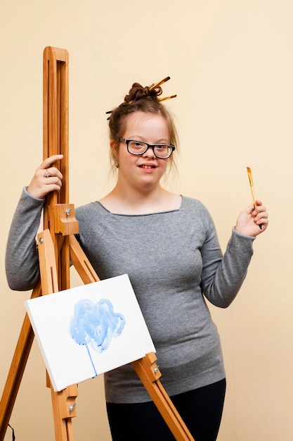 Girl with down syndrome posing with easel