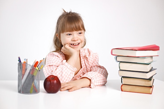 Girl with Down syndrome studying while sitting at desk at home