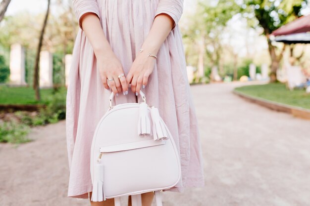 Girl with elegant manicure posing during spending time outdoor, standing on park alley