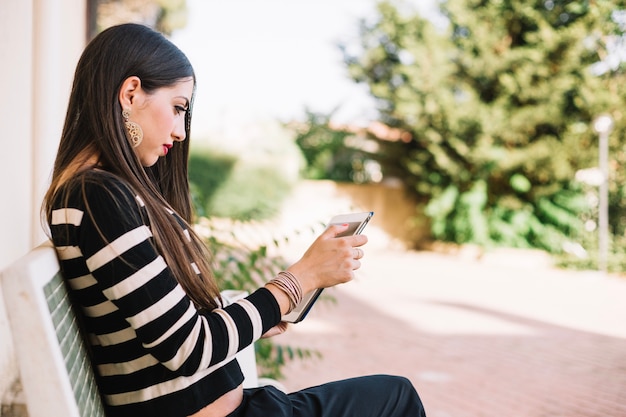 Foto gratuita ragazza con gadget sulla strada