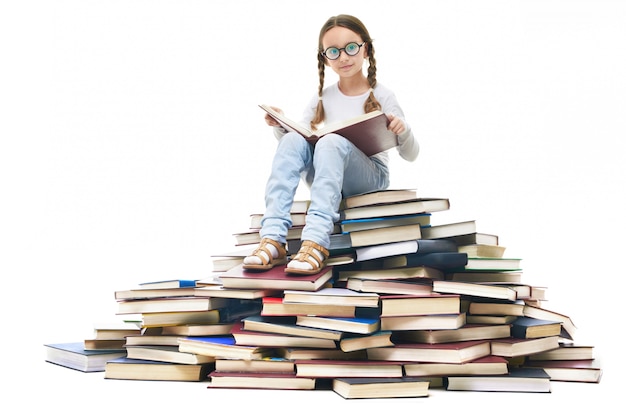 Girl with glasses sitting on a pile of books