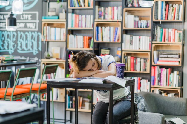 Girl with hairbun sleeping on table