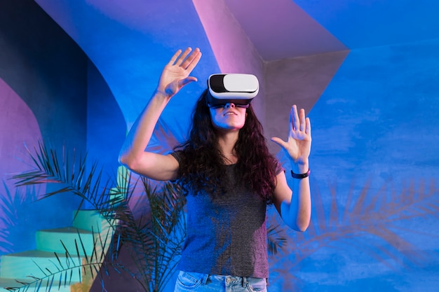 Free photo girl with hands up wearing the vr set