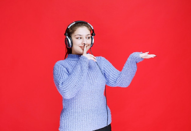 그녀는 잘들을 수 없기 때문에 침묵을 요구하는 헤드폰을 가진 소녀.