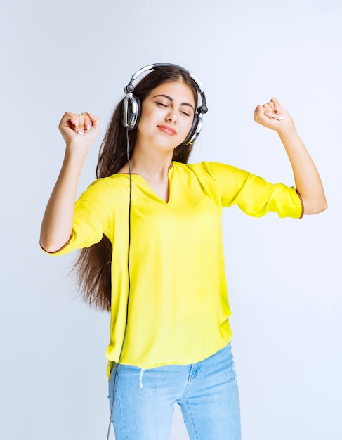 Free photo girl with headphones listening the music and dancing with passion.