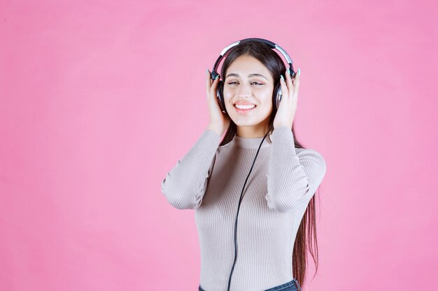 Girl with headphones listening the music and feeling happy