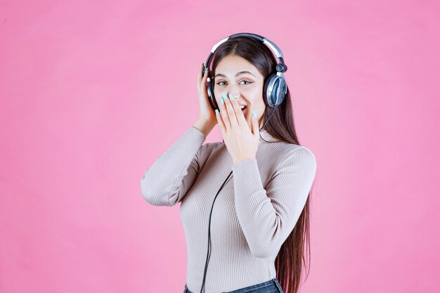 음악을 듣고 그녀의 즐거움을 보여주는 헤드폰 소녀