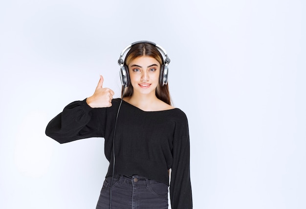 Girl with headphones showing satisfaction sign. High quality photo