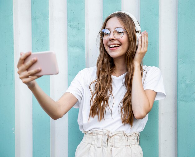 Free photo girl with headphones taking selfie