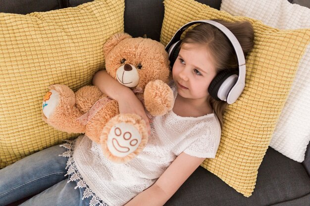 Girl with headphones and teddy