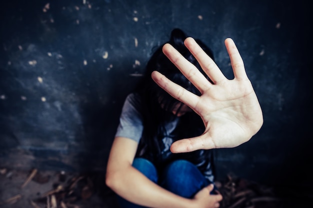 Girl with her hand extended signaling to stop useful to campaign against violence, gender or sexual discrimination