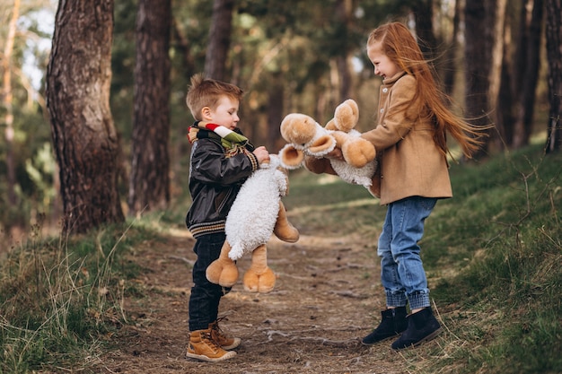 Girl with her little brother together in forest