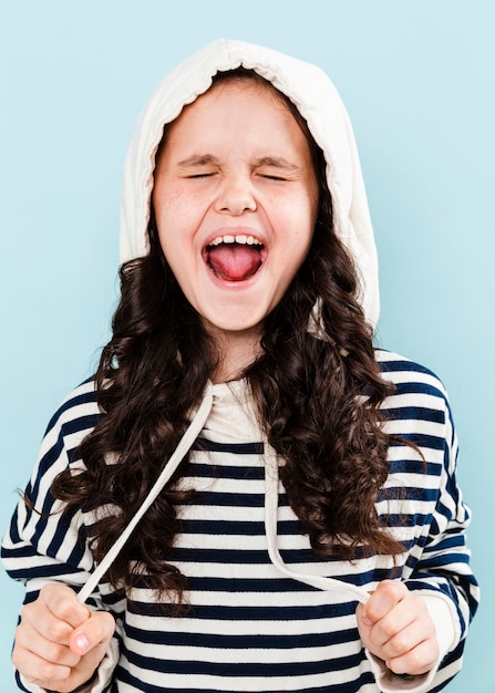 Free photo girl with hoodie making funny faces