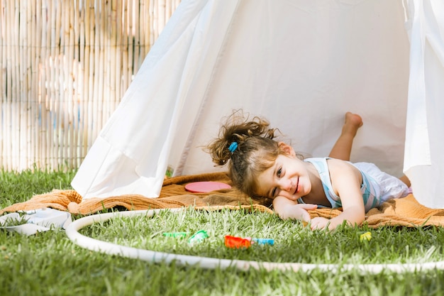 Girl with hula hoop lying in tent