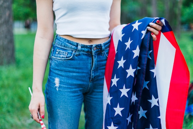Бесплатное фото Девушка с джинсами и американским флагом в природе