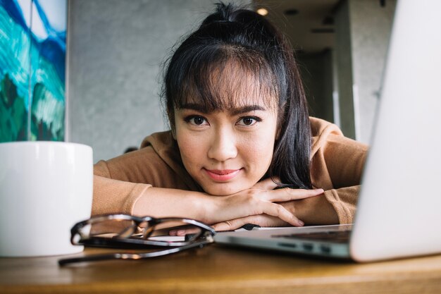 Ragazza con il computer portatile a tavola